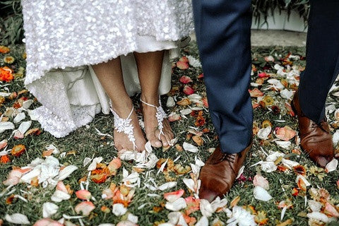 Bride and Groom's Feet Standing in Wildflower Petals Barefoot Sandals